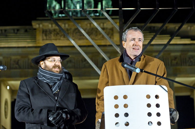 נציג הממשל בברלין מדליק חנוכייה בחזית "שער הניצחון"