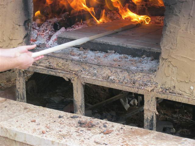 את המצה משטחים בתוך התנור. החום האדיר בתנור, מבעיר את הנייר שעל המקל.