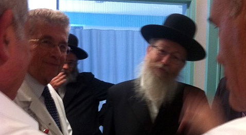 ליצמן בהתייעצות עם הרופאים. מאחור: הרב אריה אלישיב