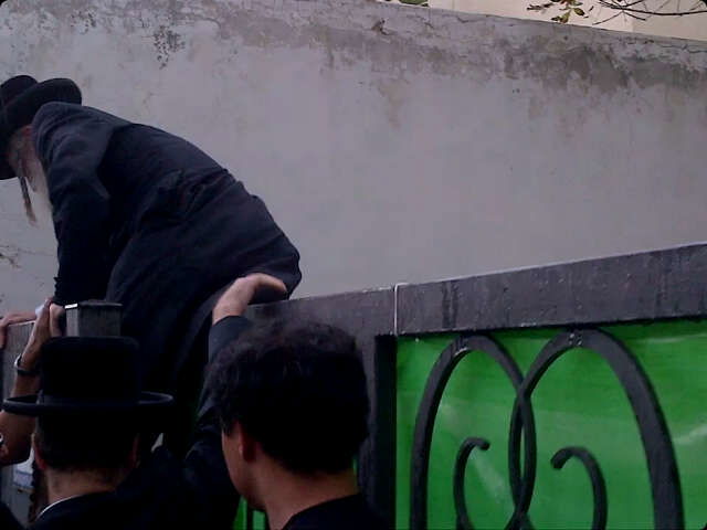 החתן מטפס על הגדר בכדי להגיע לפגישה.