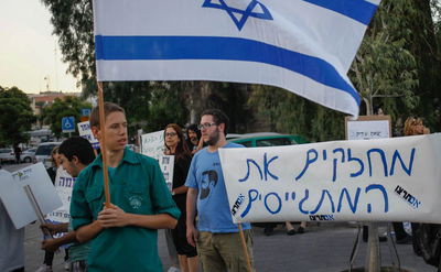 הפעילים מניפים שלטים בעד החיילים החרדים