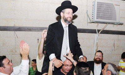 הרב דוד לאו מורם על כפיים בחגיגות הניצחון אמש