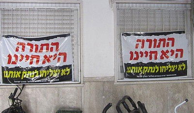 שלטי מחאה נתלו בקריית בעלזא: "לא יצליחו לנתק אותנו"