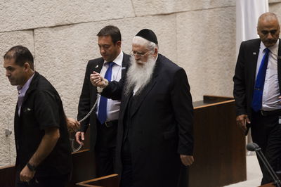 פרוש מוצא מהמליאה כשהוא כבול באזיקים