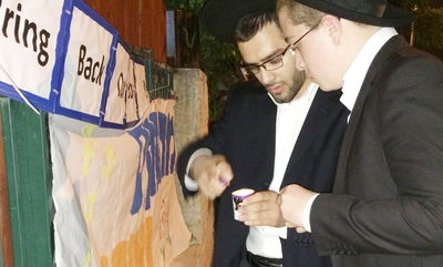 תלמידי הישיבה מדליקים נרות ליד בית משפחת יפרח