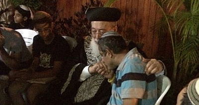 הרב עמאר בחצר הבית עם אבי המשפחה