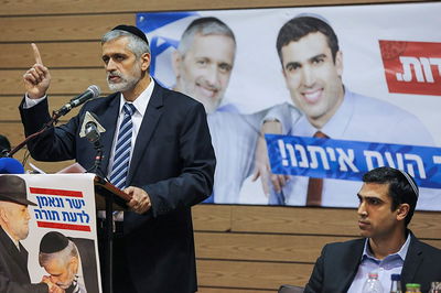 אלי ישי לצד מודעות בחירות של מפלגתו