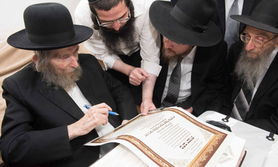 מרן הגראי"ל שטיינמן חותם על כתב ההכתרה, לצידו הגר"נ קפלן