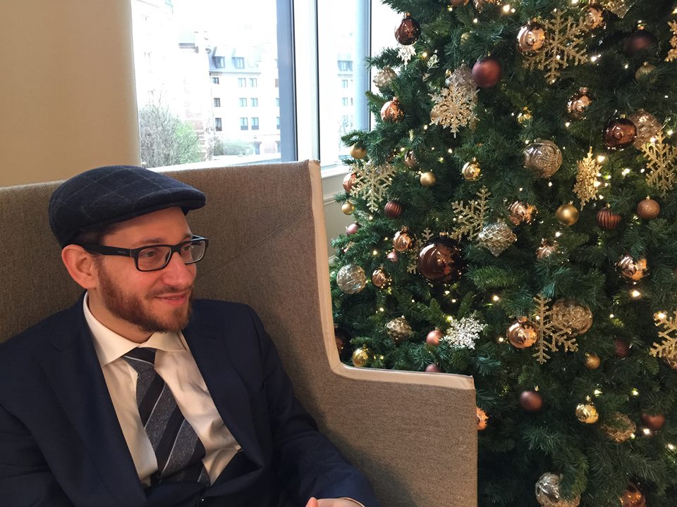 פרידמן בבית מלון על יד עץ שקושט לחג נוצרי