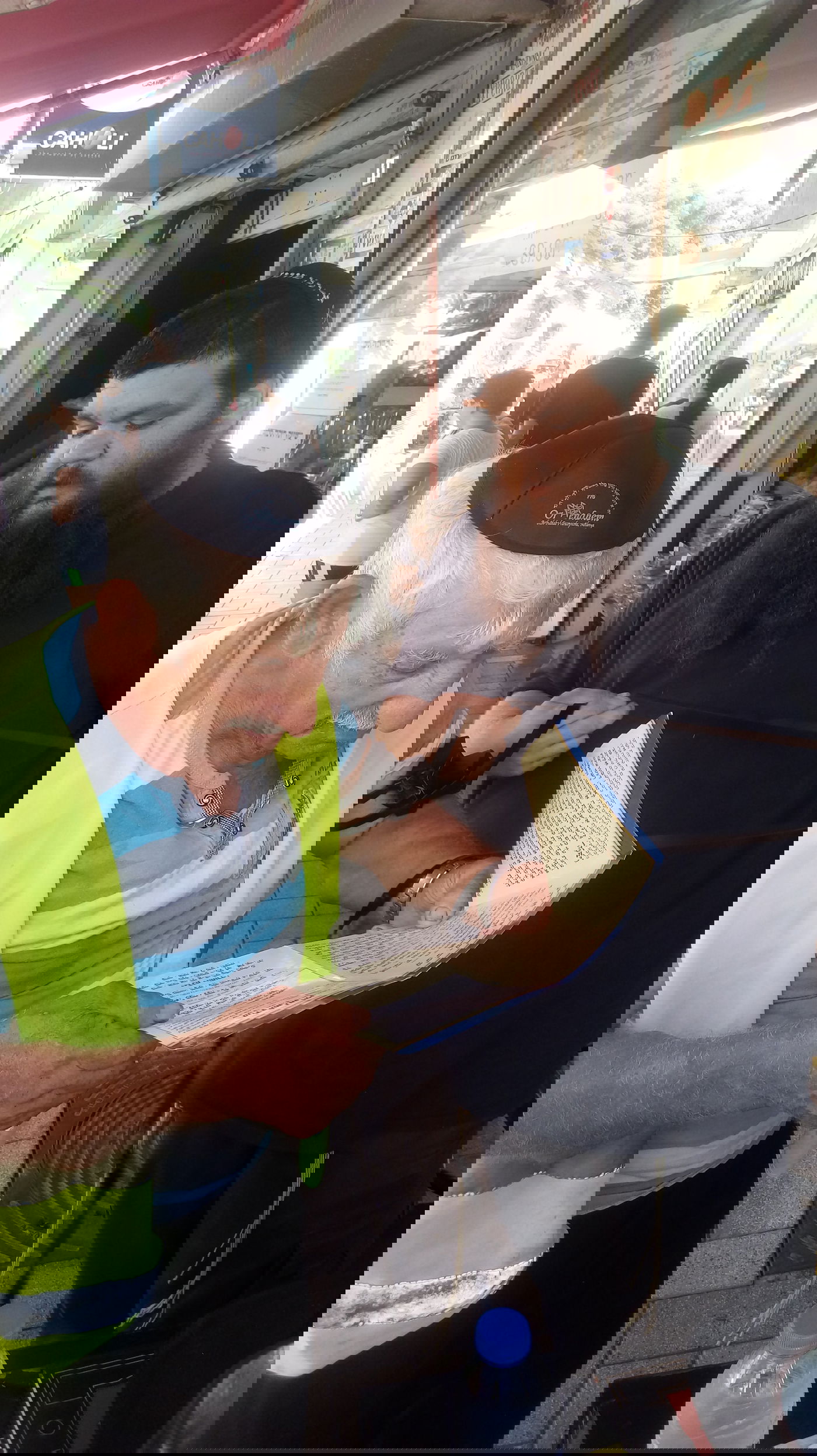 היהודי הישיש מניח תפילין עם הרב לאלום