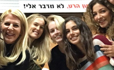 רפאלי (שניה משמאל) וחברותיה, לצד הכרזה "לשון הרע לא מדבר אלי"