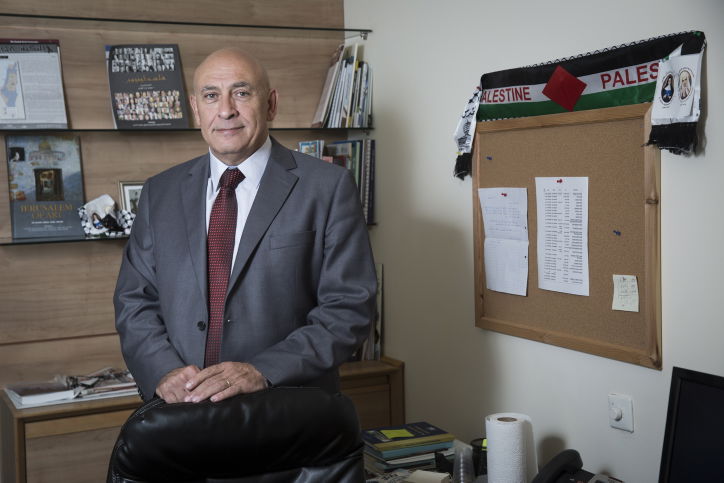 גטאס בלשכתו בה תלוי דגל פלסטין