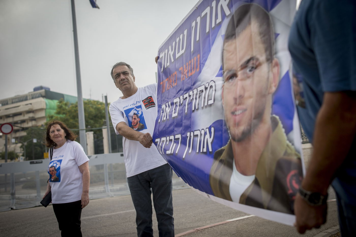 ההורים עם תמונת בנם, מפגינים. ארכיון