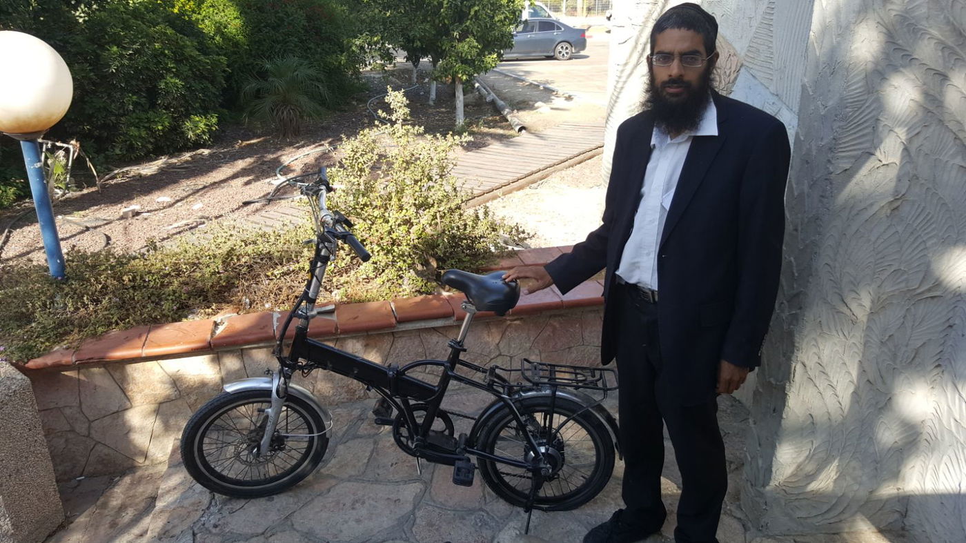 הבעלים לצד האופניים שהושבו לו