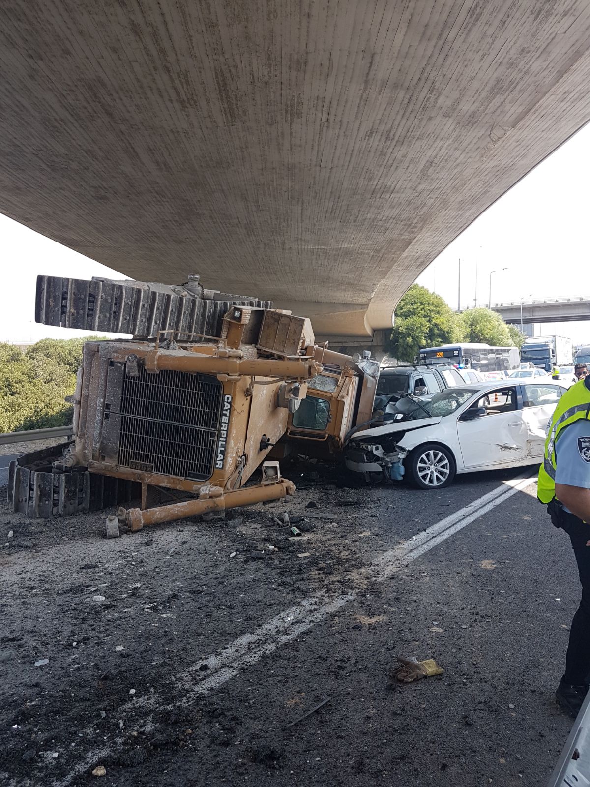 טרקטור פגע בגשר ונפל מהמשאית על רכב חולף