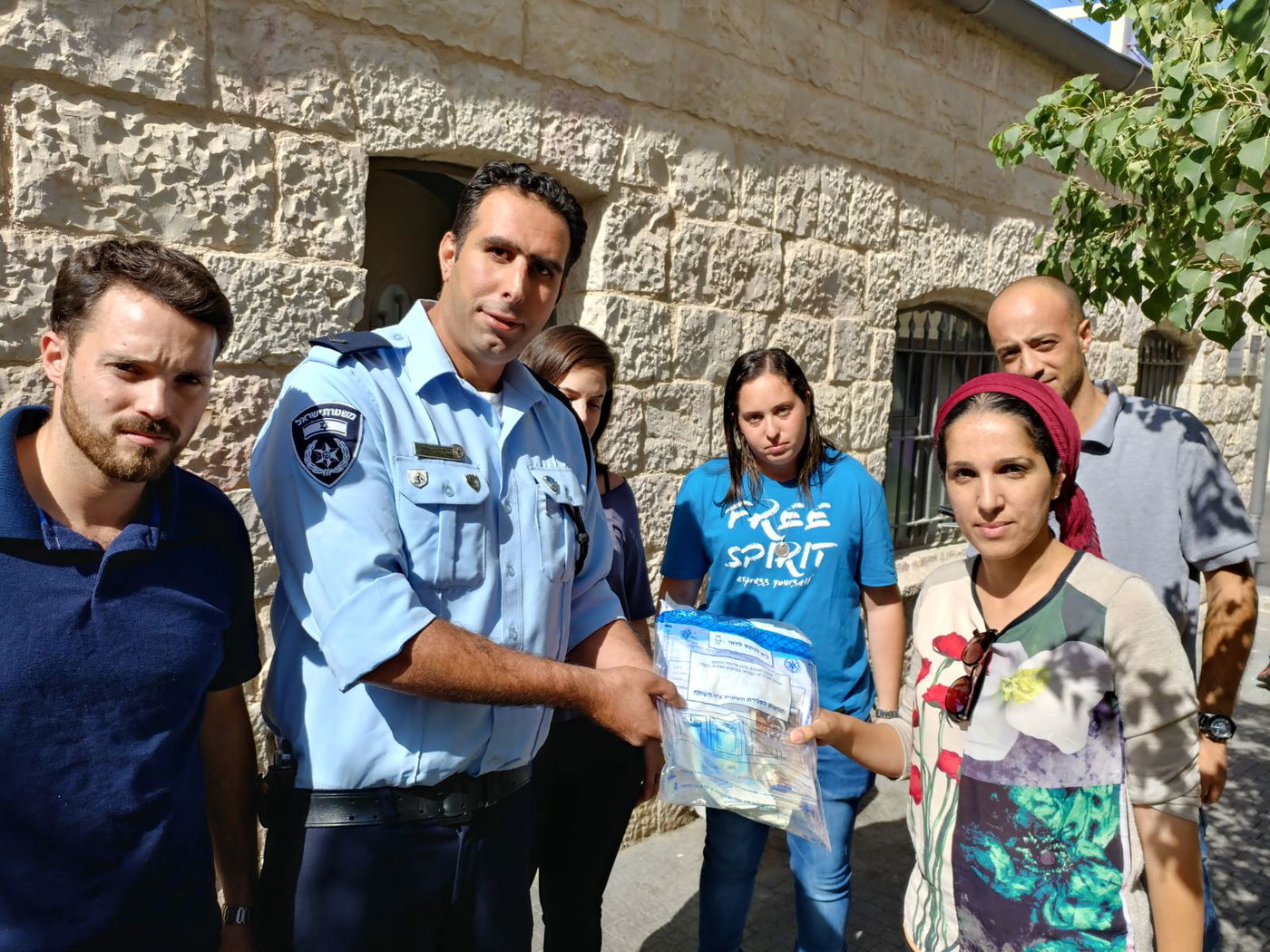 האישה מקבלת את כספה בחזרה, מידי השוטרים