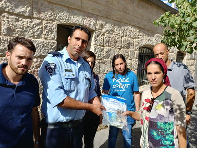 האישה מקבלת את כספה בחזרה, מידי השוטרים