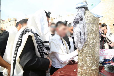 חתן הבר מצווה שגדל כילד מוסלמי קורא בתורה