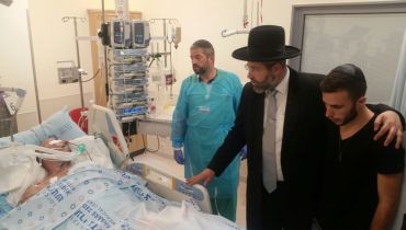 הגר"ד לאו בתפילה על יד מיטתו של המאבטח