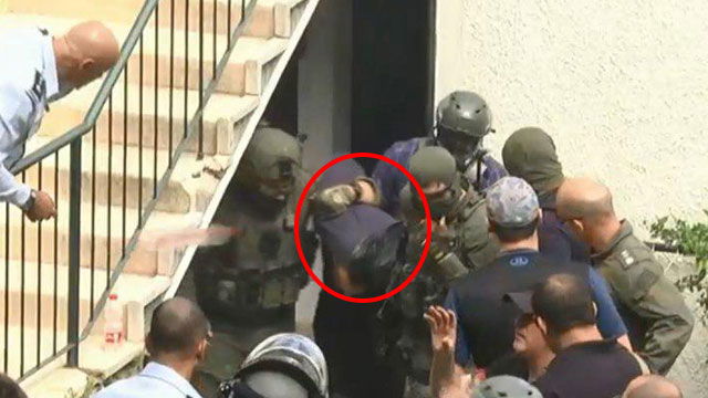 החשוד מוצא אזוק מהדירה שבה התבצר