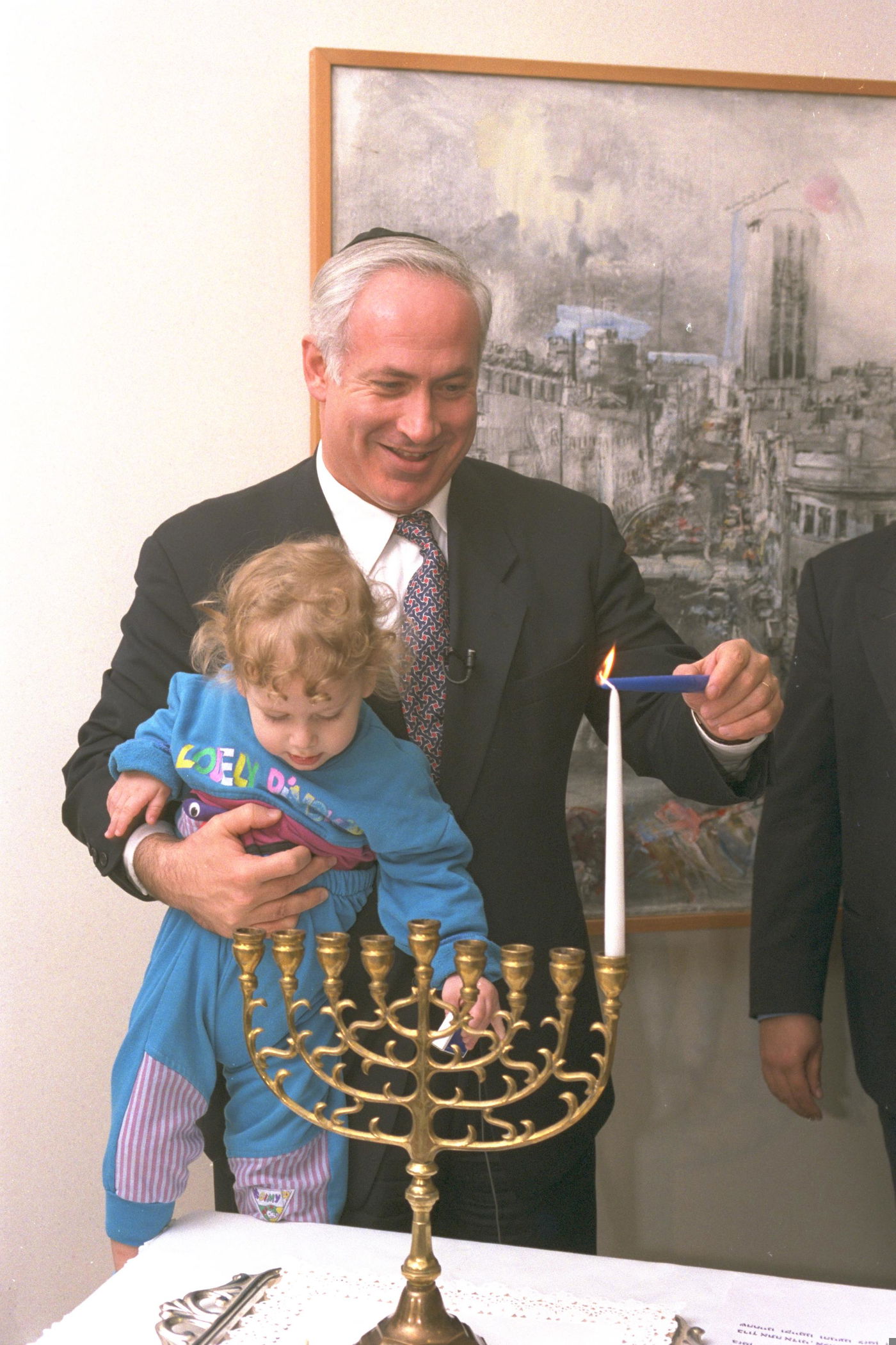 נתניהו מדליק נר ראשון של חנוכה בסיוע בנו אבנר, בלשכת רוה"מ בירושלים, ב-1996