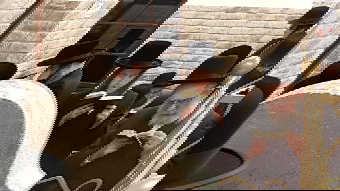 הרב (משמאל) בתפילה