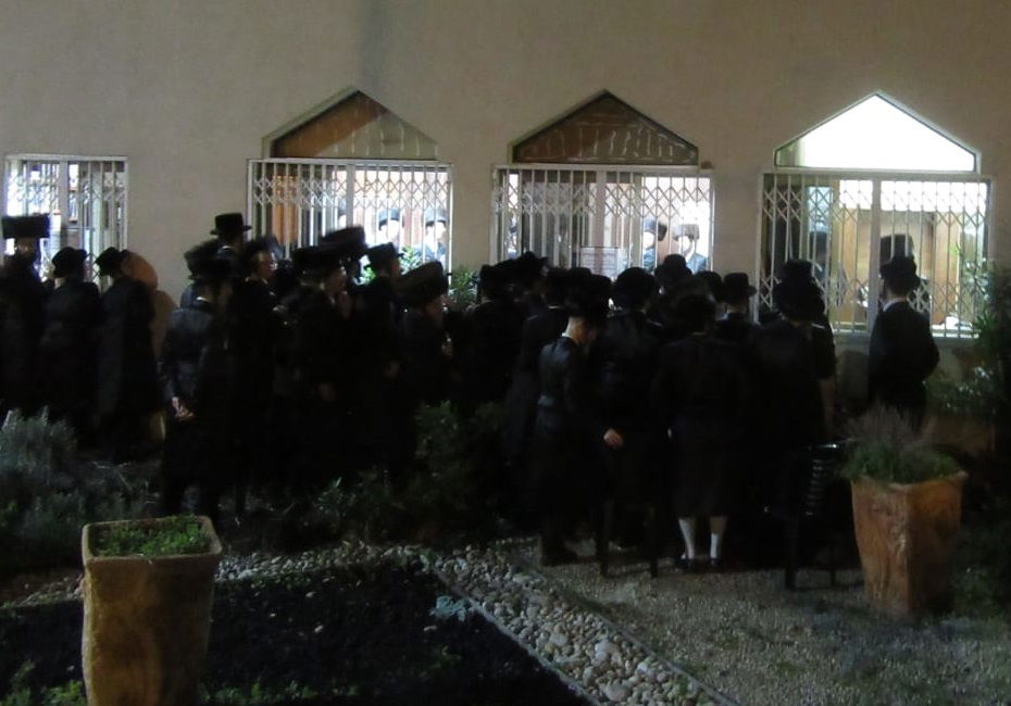 חסידי צאנז מביטים באדמו"ר, בעת ה'טיש' האחרון בביתו