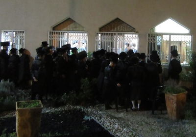 חסידי צאנז מביטים באדמו"ר, בעת ה'טיש' האחרון בביתו