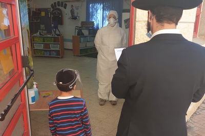 ילד מגיע עם אביו לבדיקת קורונה בעיר, השבוע