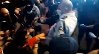 השוטר מושך את המפגינה