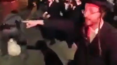 השוטר משליך את שקית האשפה לעבר החסידים