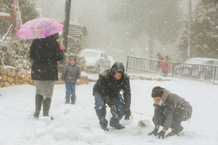 מתפללים עם טלית ותפילין ברחוב המושלג