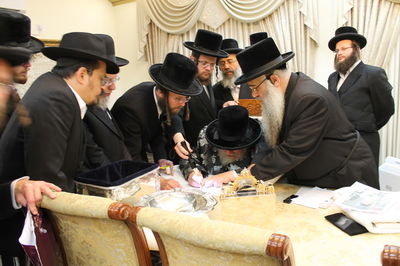 חבר מועצת גדולי התורה,  האדמו"ר מויזנ'יץ  בכתיבת האותיות, עם משלחת יד לאחים