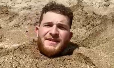 מני הולנדר קורא מחשבות בתוך החול בחוף הים • צפו