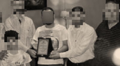 תמונה בה נראה החתן (מחזיק תעודה) עם בני משפחתו