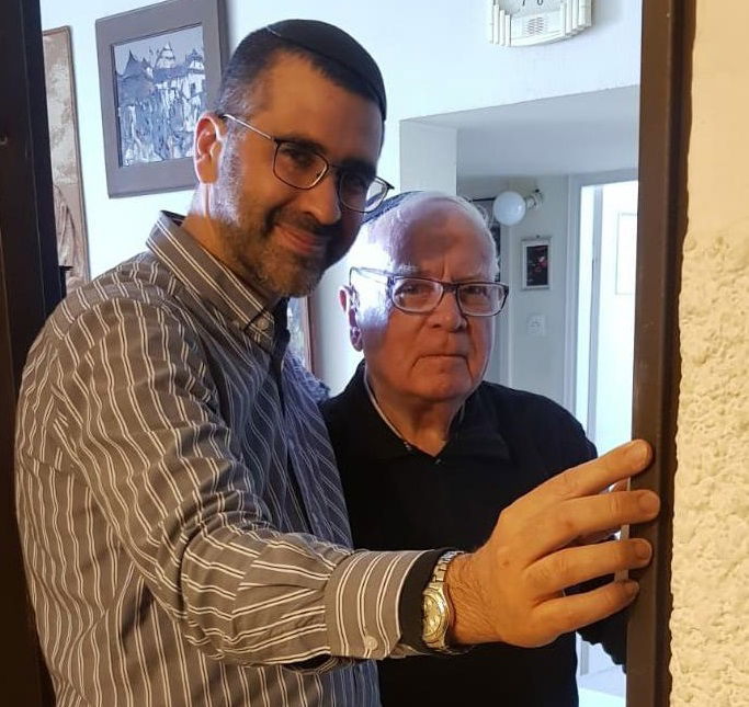 בקביעת המזוזה בביתו של גרינר, משמאל: הרב מלול