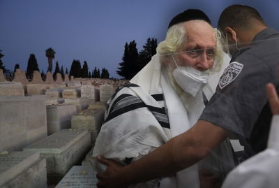 הרב ברלנד. ברקע: הרב המנוחות, שאליו הובהל אתמול