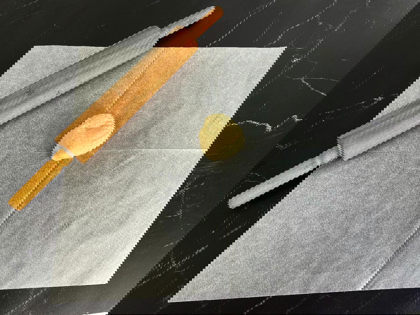 מניחים כדור בצק במרכז נייר אפייה משומן