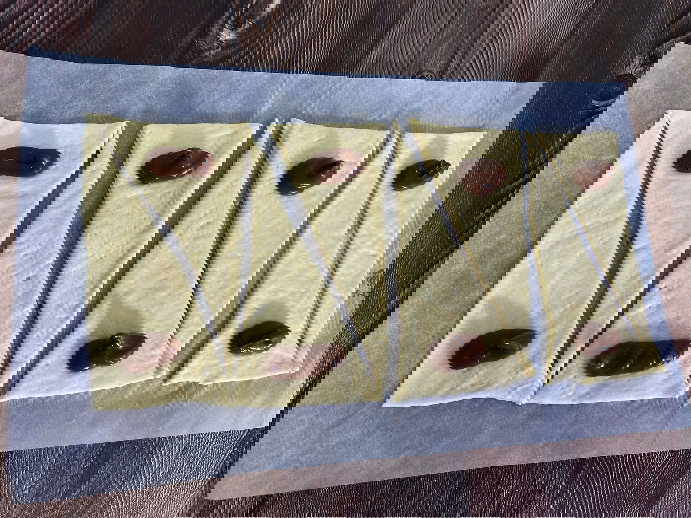 מרדדים את הבצק למלבן, חותכים למשולשים ומניחים מהמילוי בקצה