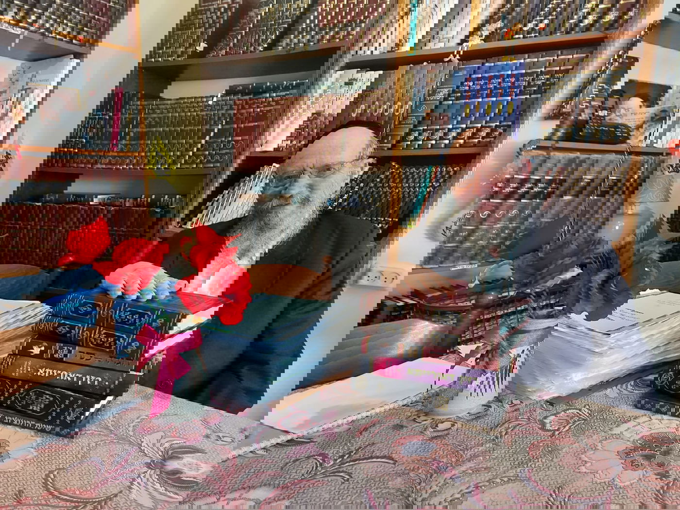 ר' מענדל טננבוים עם רוב הספרים שהוציא על הגאון הרגצו'בי