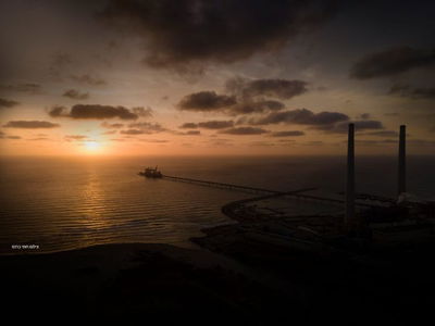 שקיעה באופק חופי חדרה, על רקע תחנת הכוח