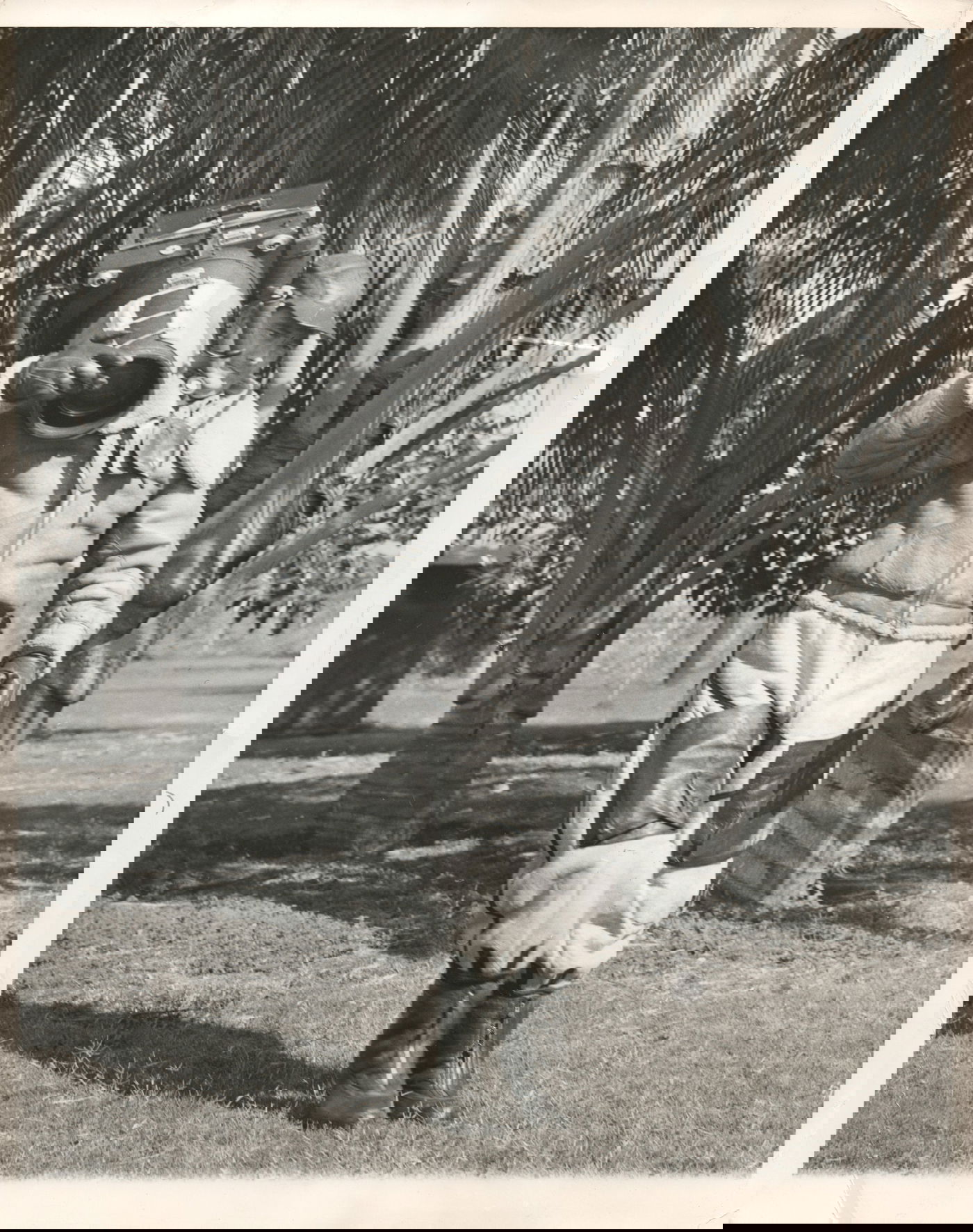 1942, ארה"ב: צלם צבאי מהחטיבה ה-7 של חיל האוויר האמריקני במדינת הוואי, סוחב מצלמת אוויר המיועדת להתקנה על מטוסים