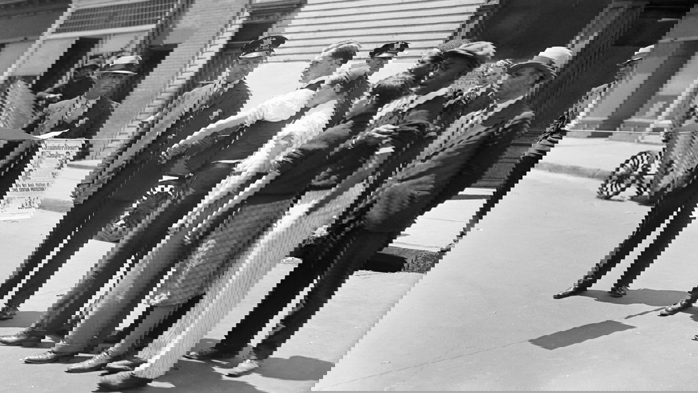 שוטרים עורכים ביקורת פתע לעוברי אורח על מנת לוודא שהתחסנו מפני אבעבועות שחורות. אופן הבדיקה: מחפשים צלקת מהחיסון בזרוע. באמצע השורה תראו ילד יהודי חובש כיפה. ניוארק ניו ג'רזי ארה"ב 1931