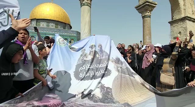 תומכי חמאס מניפים שלט אהדה לארגון הטרור, וקוראים: "אנחנו אנשיך יא חמאס"