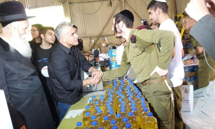 שרוליק לוחץ את ידו של לפיד בשנת 2016