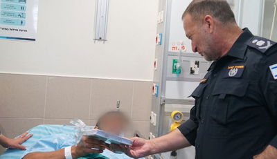 המפכ"ל מעניק ספר למסתערב שנפצע