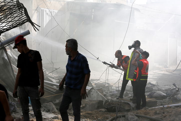 כוחות עזתיים בחיפוש אחר ניצולים בבניין שהופצץ