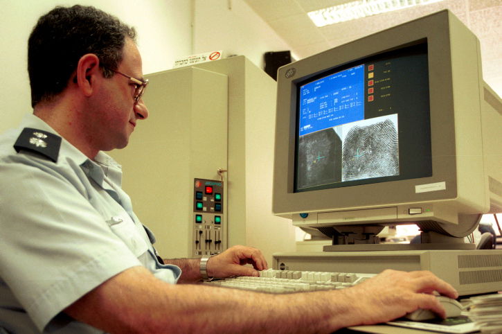 שוטר עובד על זיהוי לפי טביעות אצבע