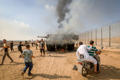 מחבלים בשטח ישראל לצד טנק ישראלי שנפגע במתקפה