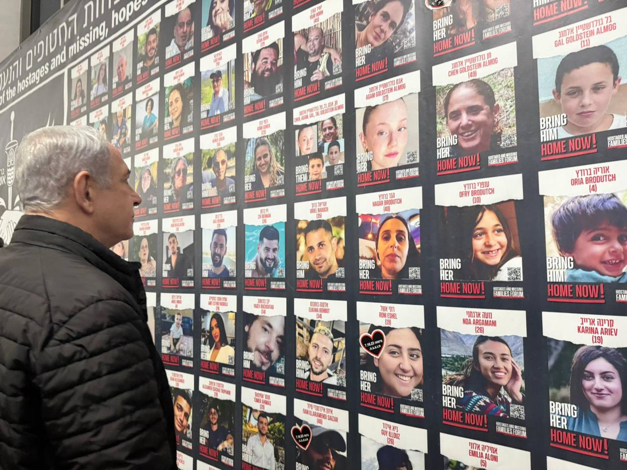 נתניהו מביט על תמונות החטופים בקריה, תל אביב